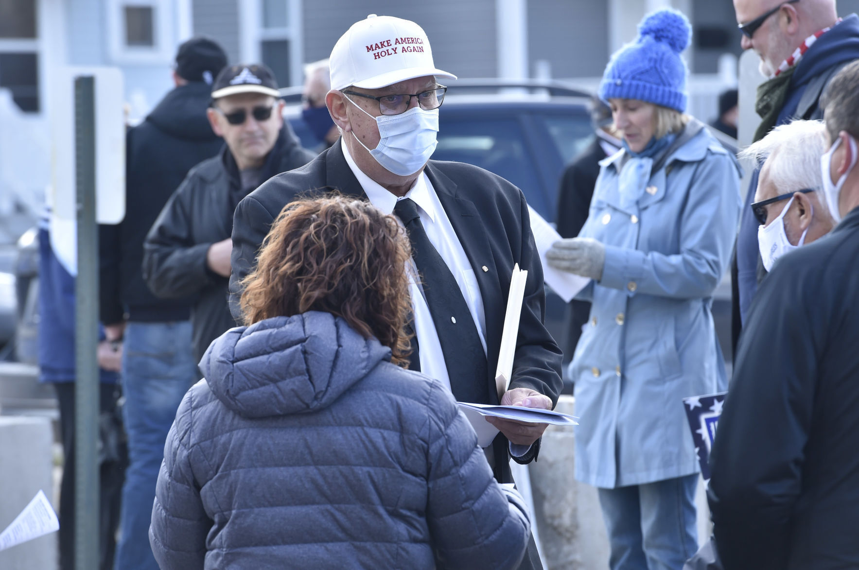 A volunteer at Kenosha's Unite Our Nation event passes out song sheets